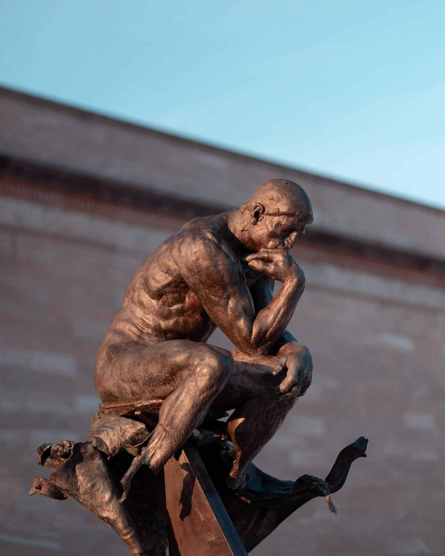 The thinker sculpture poses thoughtfully.
