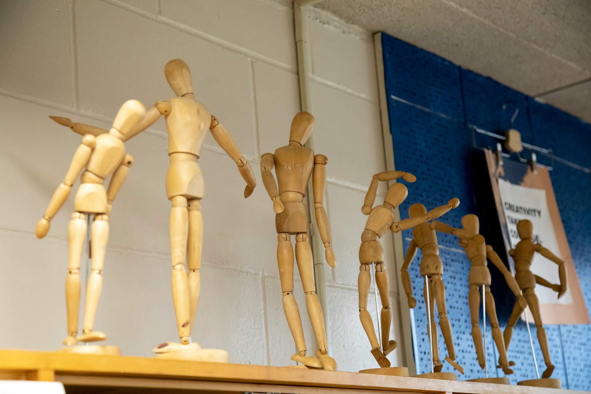several wooden mannequins on a shelf in a room